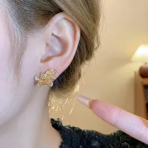 Elegantes pendientes de botón de unicornio dorado con circonitas y agujas de plata en oreja