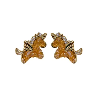 Elegantes pendientes de unicornio dorados con brillantes piedras de ámbar y cristales.