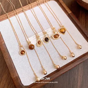 Vintage Maillard style gold necklaces with amber resin pendants displayed on a tray.