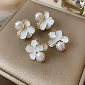 Vista dettagliata di eleganti orecchini di perle a forma di fiore placcati oro 18k.