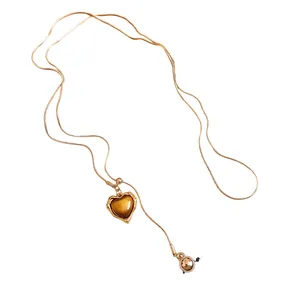 Retro Maillard style golden snake chain necklace with an amber heart resin pendant