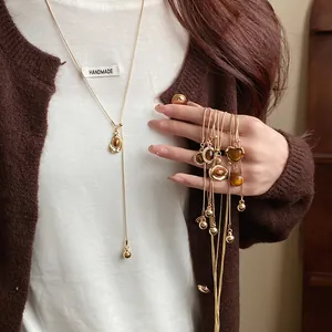Close-up showing various vintage resin pendant necklaces in Maillard brown and gold tones