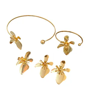 Vintage golden metal flower jewelry set with necklace and bracelet on white background