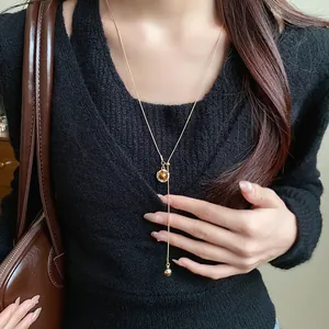 Detailed view of a minimalist vintage oval resin pendant necklace in Maillard brown style