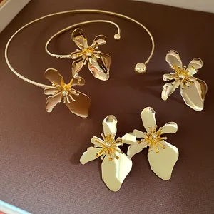 Macro detail of retro golden metal flower necklace, bracelet and earrings jewelry set.