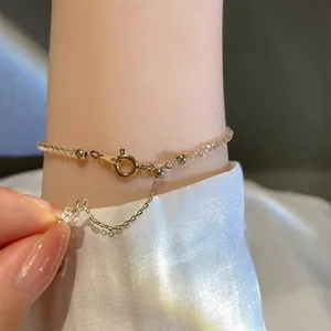 Detailansicht eines minimalistischen Kristallarmbands mit goldenem Verschluss und Kette.