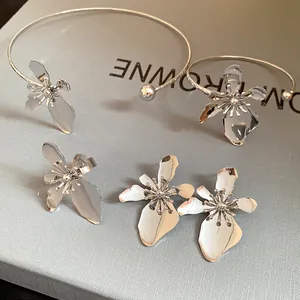 Detail shot of a vintage silver metal flower jewelry set with necklace and earrings