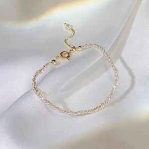 Nahaufnahme von eleganten champagnerfarbenen Kristallperlen auf einem Goldarmband