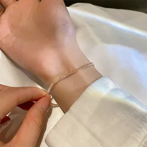 Detailaufnahme eines minimalistischen Champagner-Kristallperlenarmbands am Handgelenk
