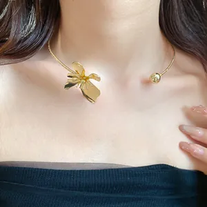Detailed close-up view of a vintage gold metal flower choker necklace on a model's neck
