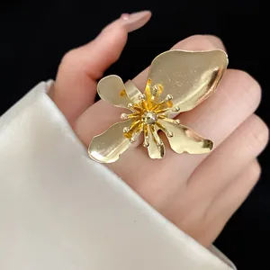 Detailed close-up view of an oversized gold metal flower ring with textured petals