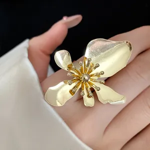 Close-up detail showing the intricate petals of a vintage gold metal flower statement ring
