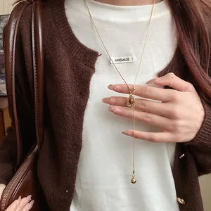 Detail view of vintage gold lariat necklace with an oval amber resin pendant