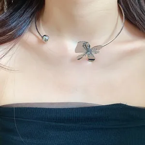 Detailed view of a stylish silver-toned metal flower choker necklace worn on model