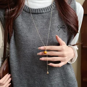 Detailed view of a vintage resin pendant necklace on a minimalist adjustable gold chain