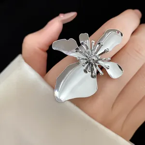 Macro view of a large silver metallic flower ring featuring intricate stamen details