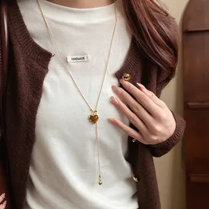 Close-up of a heart-shaped resin pendant necklace in Maillard retro style on a model