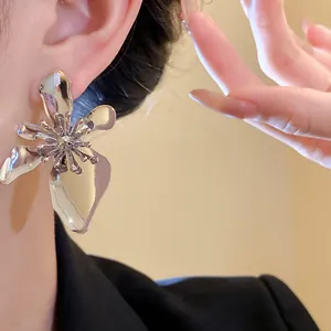 Close-up detail of a high-end vintage silver metal flower earring worn by a model