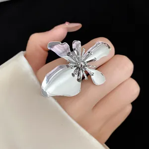Detailed close-up view of a stylish vintage silver-toned large metal flower ring worn on a hand