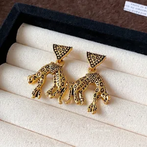 Vintage gold leopard drop earrings with triangle studs in a premium jewelry box
