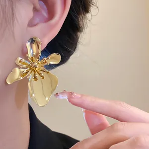 Detailed view of elegant vintage gold metal flower earring worn on ear with high-end style