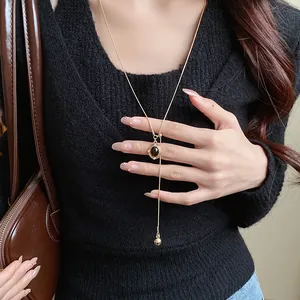 Elegant vintage Maillard style oval resin pendant necklace worn over a black sweater.