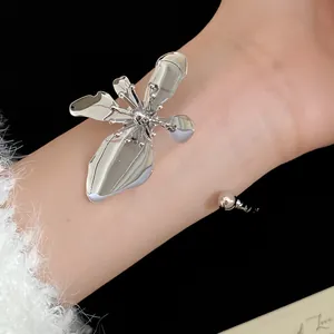 Elegant silver metal flower cuff bracelet detail on a model wrist for fashion style