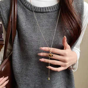 Detailed view of an oval resin pendant necklace in retro Maillard style on a model