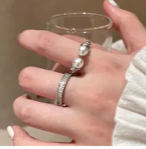 Detailed view of an open ring featuring shimmering zircons and twin elegant pearls
