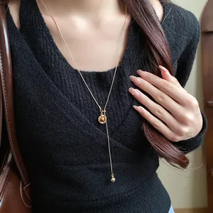 Detail shot of an oval resin pendant necklace in Maillard retro style on a model