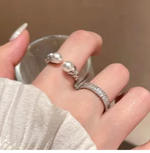 Detailed shot of elegant silver-colored ring with pearls and zircon band