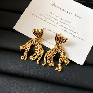 Macro detail shot of vintage leopard stud earrings with golden finish and black spots.
