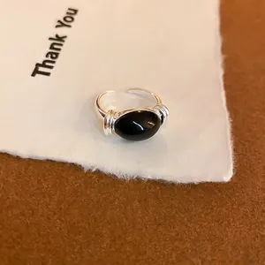 Vista macro de un anillo plateado vintage con centro de esmalte negro
