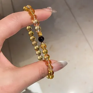 Detailed view of a citrine and agate beaded bracelet featuring golden flower accents
