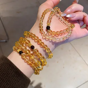 High-quality close-up of multiple Maillard style citrine beaded bracelets on a hand