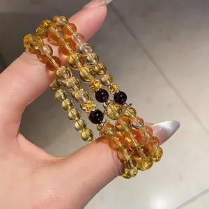 Detailed macro shot of citrine and agate bead bracelets featuring delicate gold flower spacers
