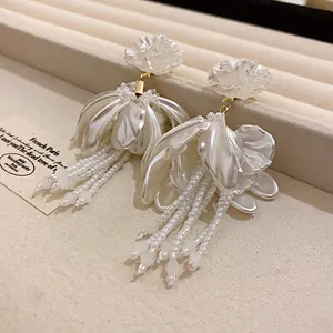 Detailed macro view of elegant white floral tassel earrings featuring exquisite pearly petals
