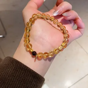 Detailed macro view of a vintage citrine and agate beaded bracelet on a woman's hand