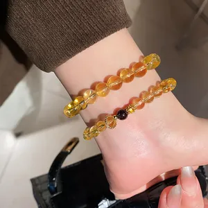 Close-up detail of a yellow crystal and agate flower bracelet with vintage gold charm