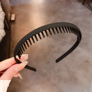 Close-up detail of a matte black anti-slip headband with fine comb teeth for hair.