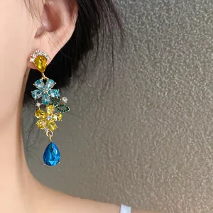 Vista detallada de pendientes de borla con flores de cristal y colgante de gota azul grande