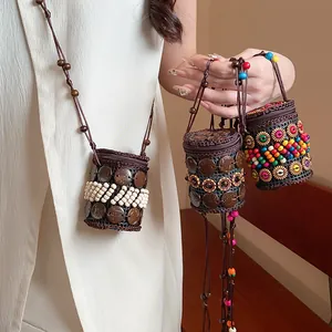 Detail view of handmade Bohemian style coconut shell and bead cylindrical mini necklace bags