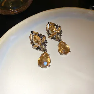 Primer plano de pendientes de flor elegantes con gotas de cristal color ámbar