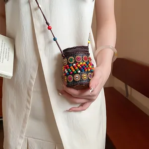 Macro detail of Bohemian ethnic style coconut shell beaded necklace bag worn by model
