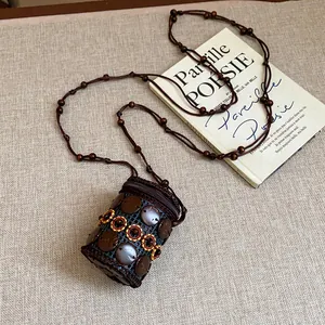Close-up of Bohemian coconut shell necklace with unique embroidered pattern detail.