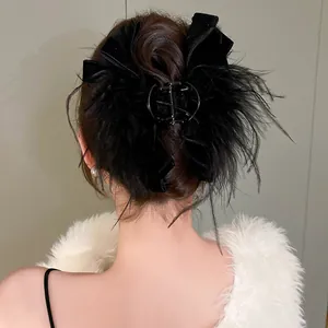 Primo piano di un'elegante molletta per capelli nera con piume e fiocco su una modella