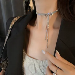 Gros plan d'un élégant collier choker avec nœud en strass et pompons.