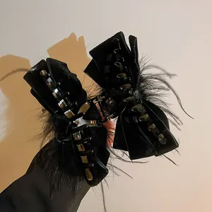 Dettaglio di un'elegante molletta per capelli a fiocco in velluto nero con piume fini