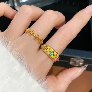 Primo piano di anelli retrò placcati in oro con pietre preziose su una mano femminile.