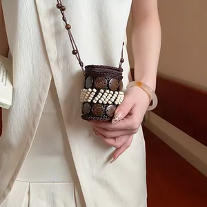 Detail of a Bohemian coconut shell and beaded decorative pendant necklace on a model.
